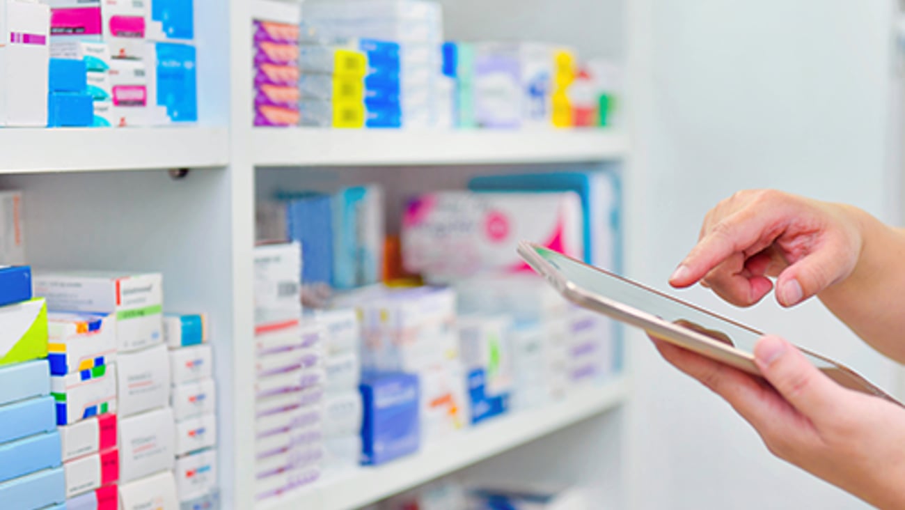 A person checking medications in a stock room.