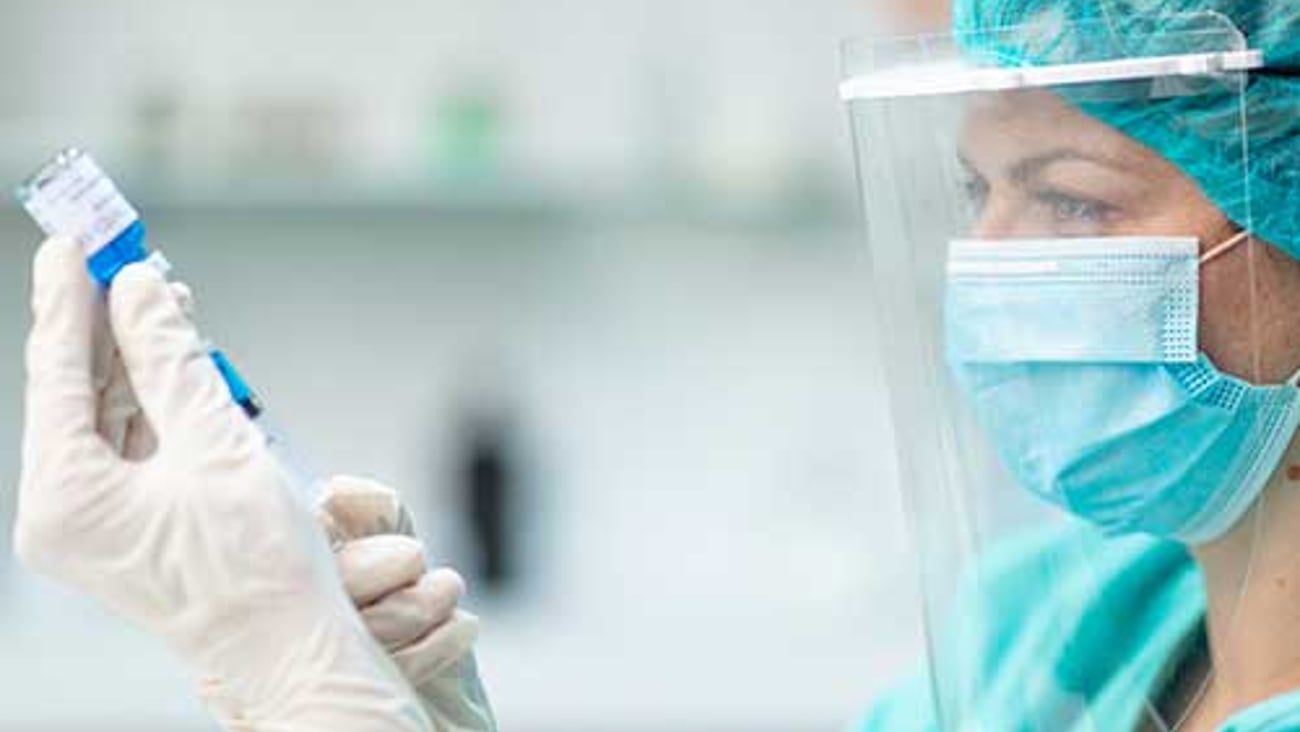 A healthcare worker getting a vaccine ready.