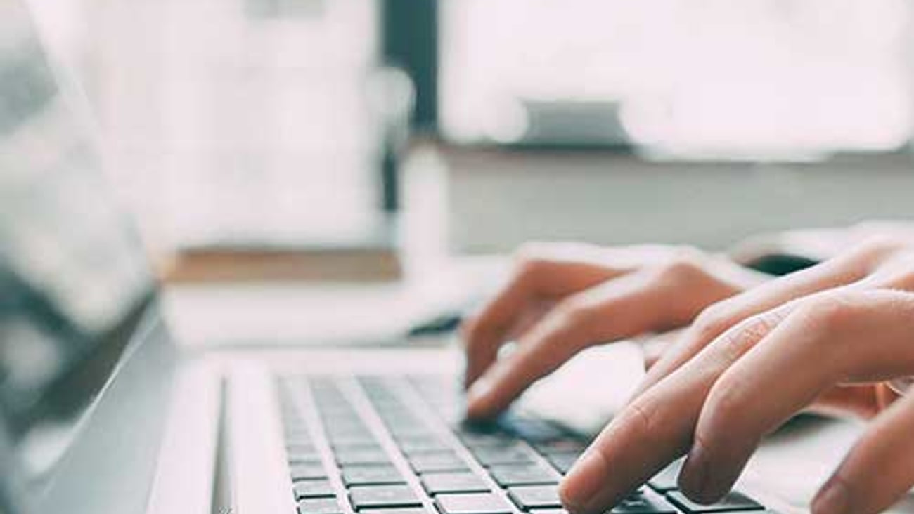 Hands typing on a keyboard.