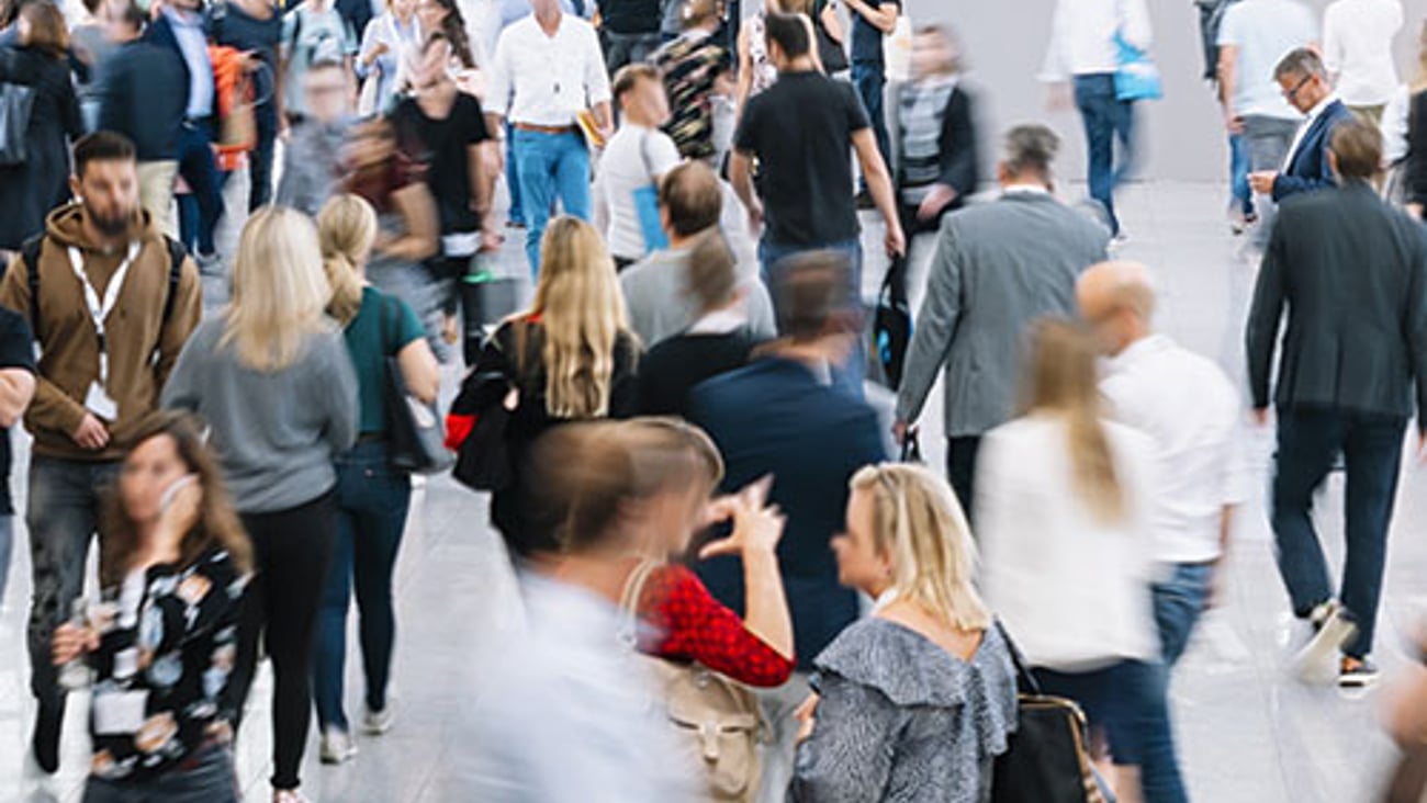 A group of people walking in front of a crowd