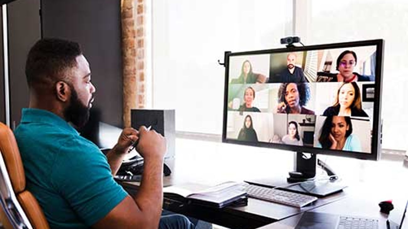 Man sitting a a computer for a virtual meeting.