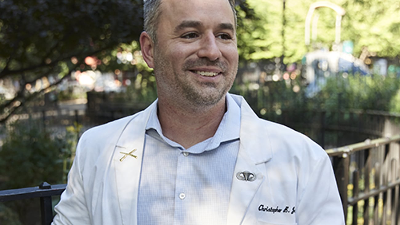 a man standing in front of a fence