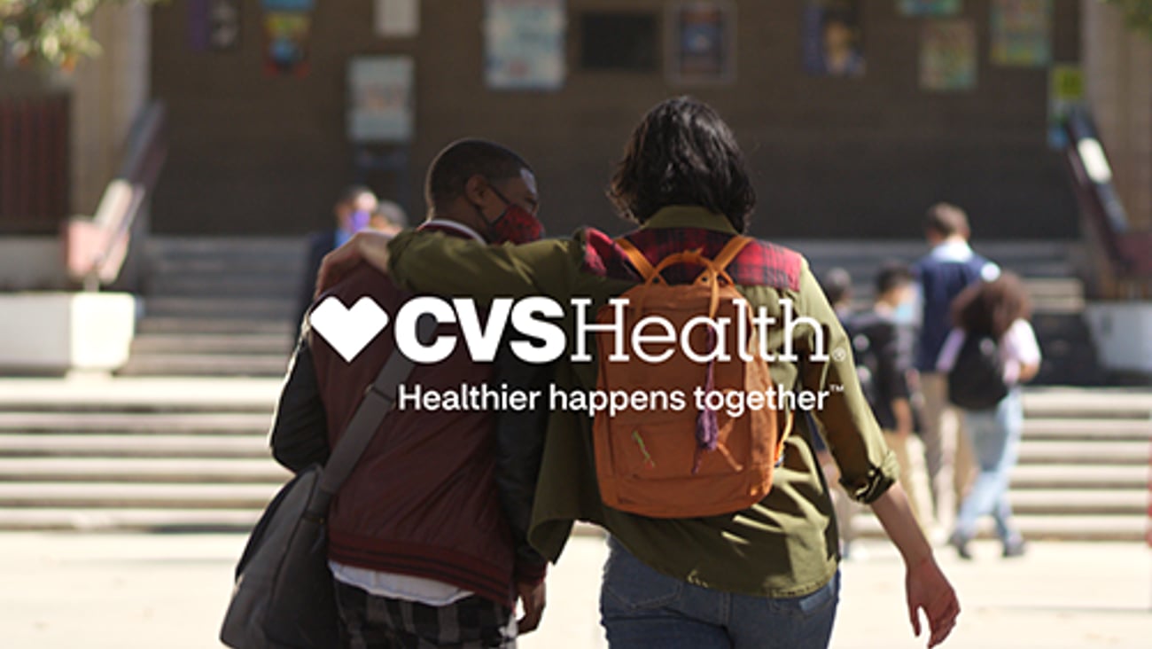 Two people walking with CVS Health logo