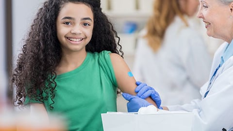 A healthcare worker giving an immunization to a girl.