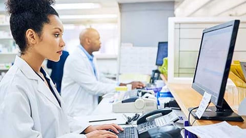 A female pharmacist at a computer. 