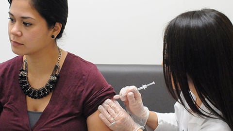 A Walgreens pharmacist giving a patient a vaccine. 