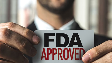 A man holding an FDA approved sign. 