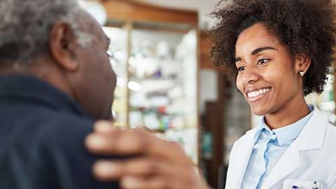 A pharmacist touching a patient's shoulder.