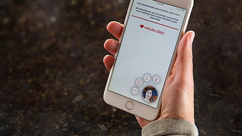 A hand holding a cell phone for a telemedicine visit.