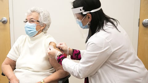 CVS pharmacist giving a senior a vaccine.