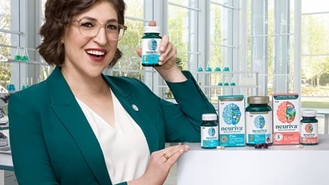 Mayim Bialik standing in front of a window