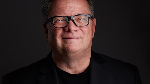 a man wearing glasses and looking at the camera