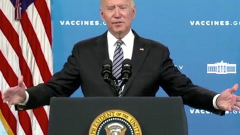 Joe Biden holding a sign posing for the camera