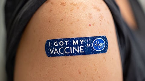 An arm with a bandaid affer a vaccine.