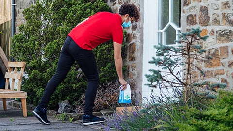 A person delivering a package to a house.