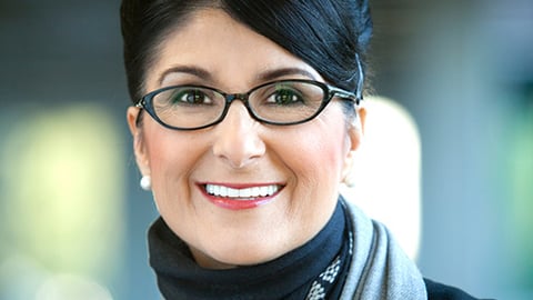 a person wearing glasses and smiling at the camera