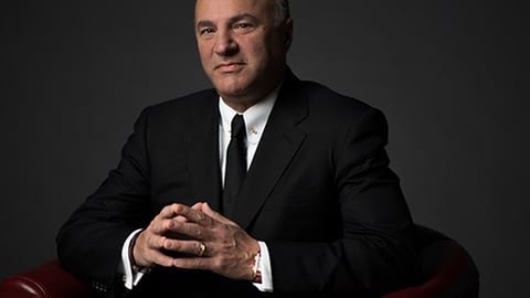 Kevin O'Leary wearing a suit and tie sitting in a chair