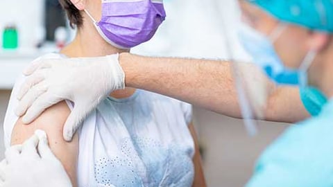 A healthcare worker giving a vaccine.