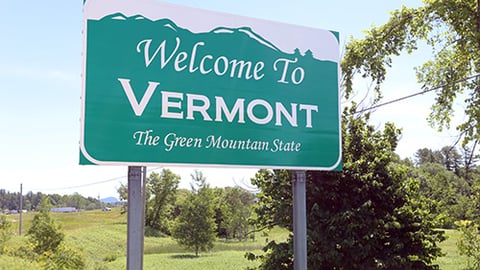 a close up of a street sign with trees in the background