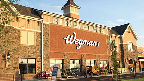 a large brick building with a clock on the side of a road