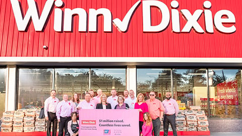 a group of people standing in front of a sign