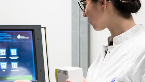 Female pharmacist taking inventory at terminal