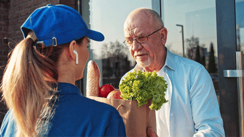 Woman delivering groceries to man