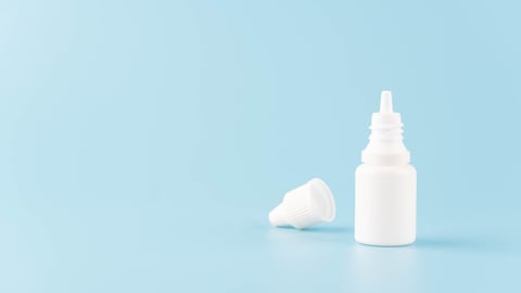 Eye drop or ear drop bottle on light blue background. Blank white plastic container for fluid. Pharmaceutical packaging product.; Shutterstock ID 1775224433