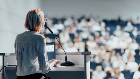 Female speaker giving a talk on corporate business conference. Unrecognizable people in audience at conference hall. Business and Entrepreneurship event; Shutterstock ID 2480862361