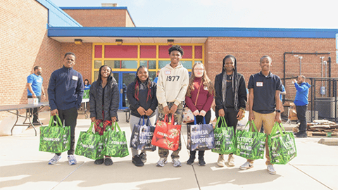 students holding bags of donated food