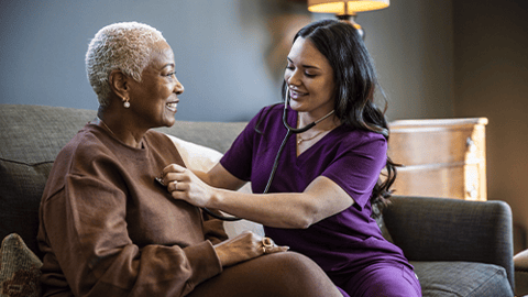 healthcare worker using stethoscope on patient