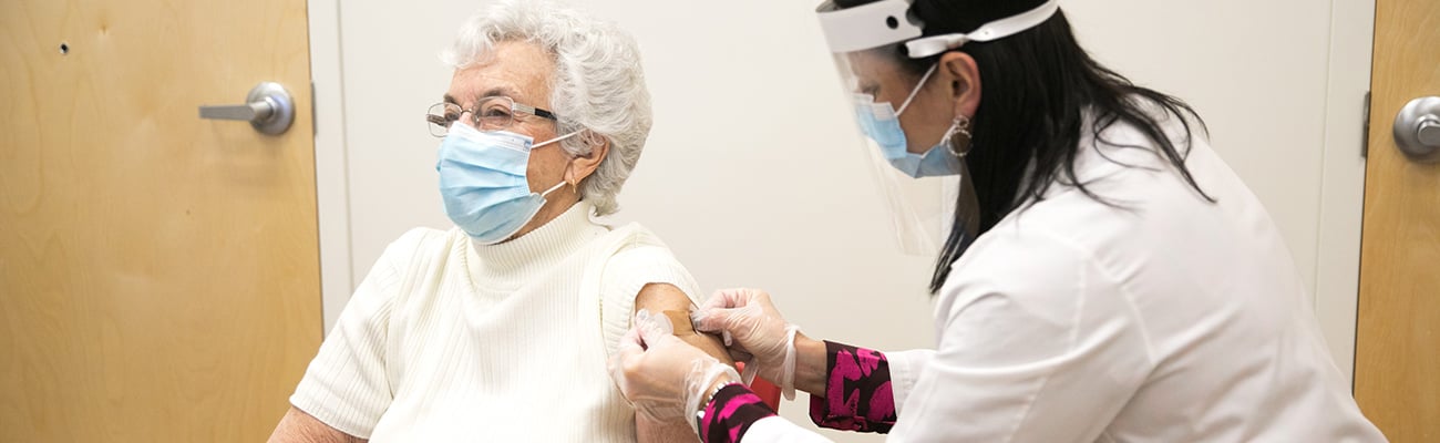 CVS pharmacist giving a senior a vaccine.