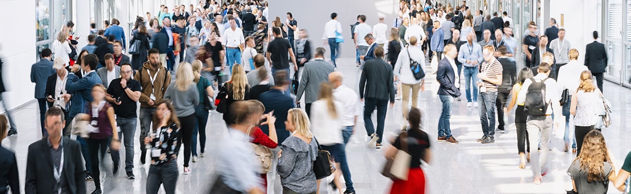 A group of people walking in front of a crowd