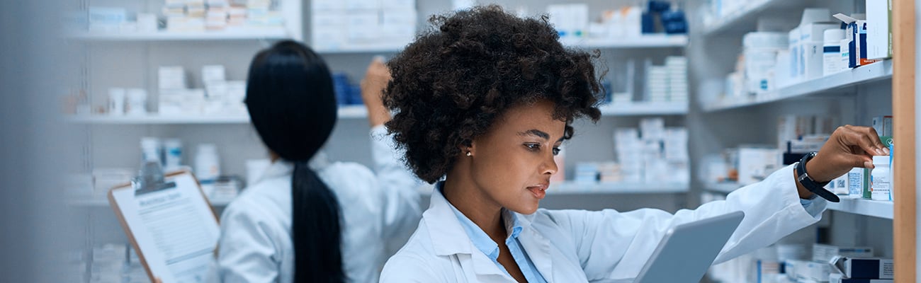 Two female pharmacists in a stock room.