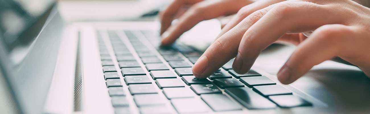 A close up of someone typing on a keyboard.