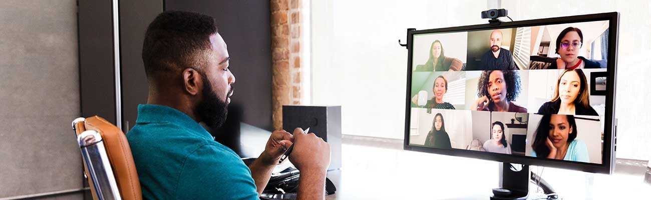 A man sitting at a computer for a virtual meeting.