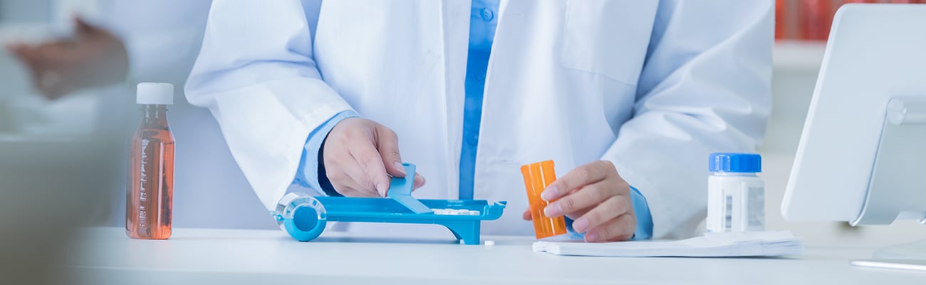 Female pharmacist counting prescription medication