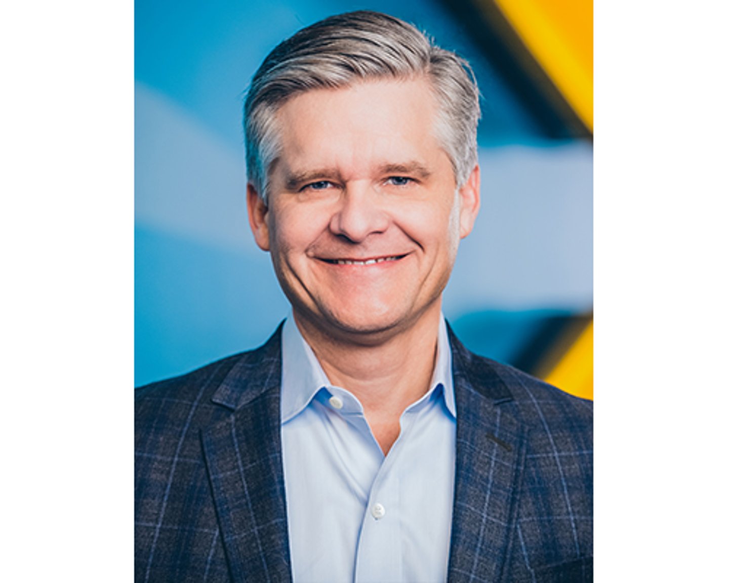 a man wearing a suit and tie smiling at the camera