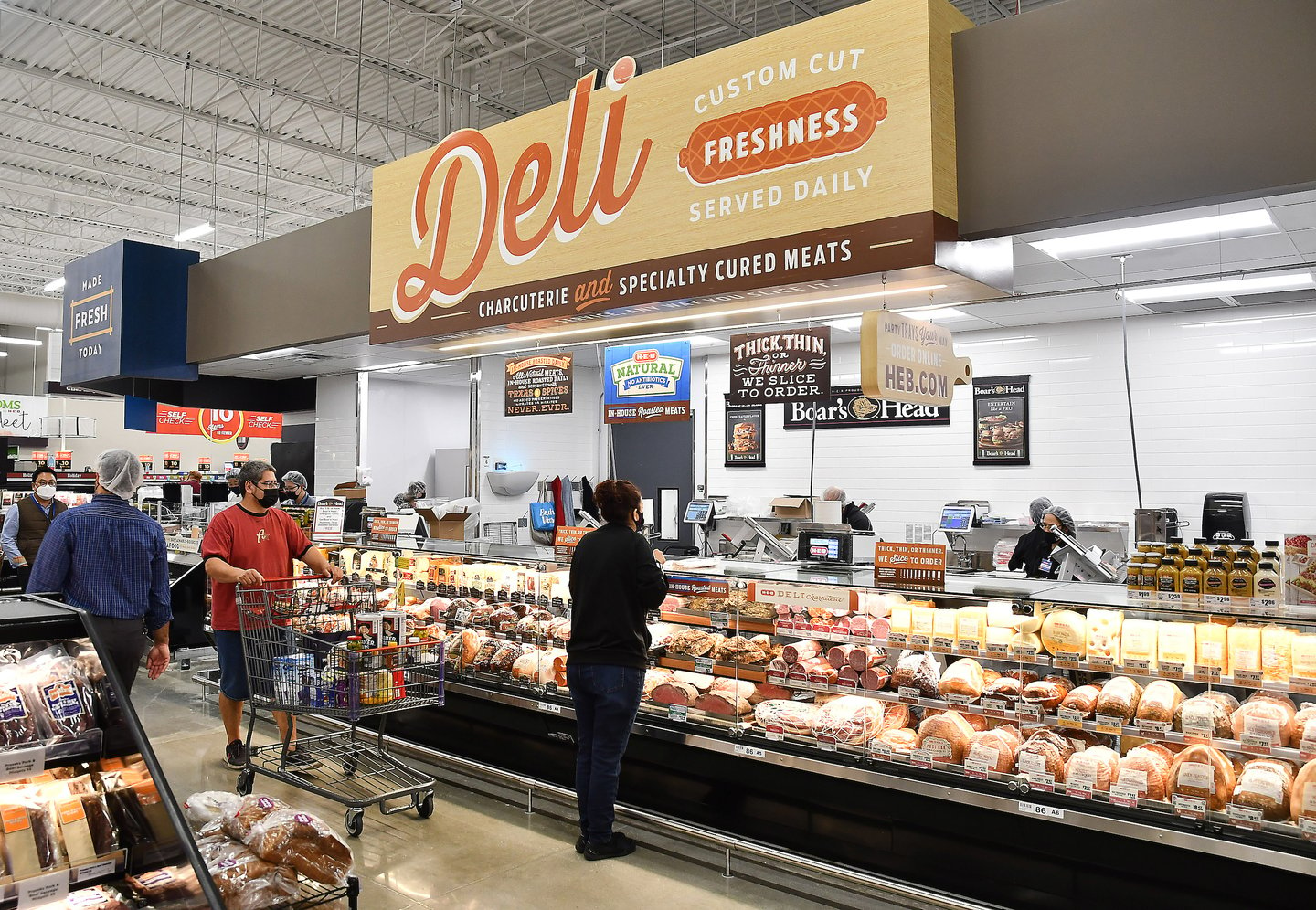 a group of people in a store filled with lots of food