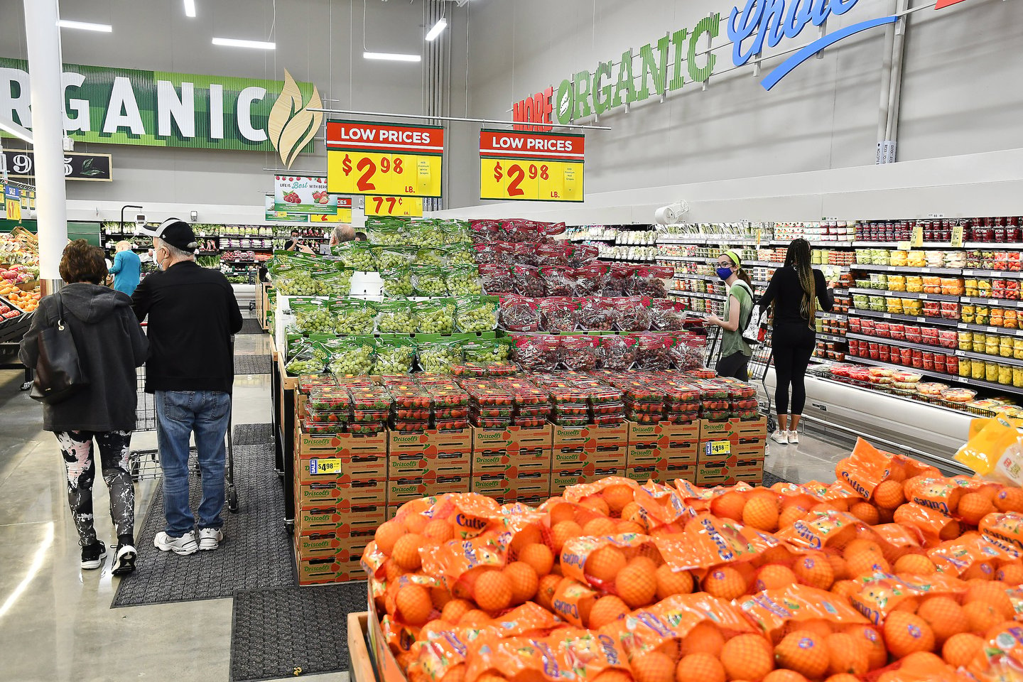 a group of people standing in front of a produce stand