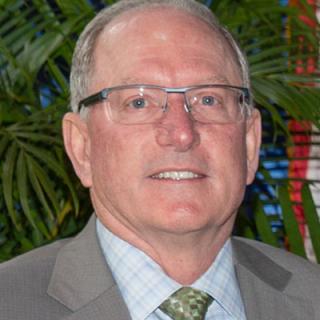 a man wearing a suit and tie smiling at the camera