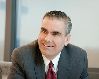 Brian McNamara wearing a suit and tie smiling at the camera