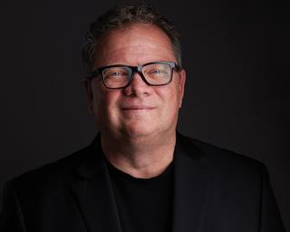 a man wearing glasses and looking at the camera