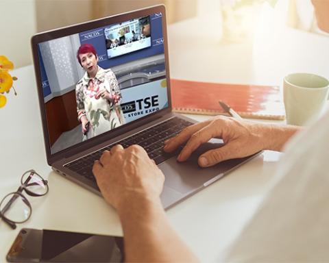 a person sitting at a table using a laptop