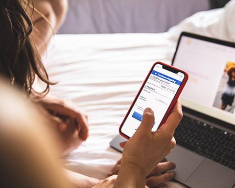 a woman sitting on a bed using a laptop