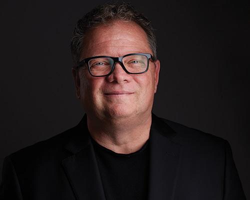 a man wearing glasses and looking at the camera